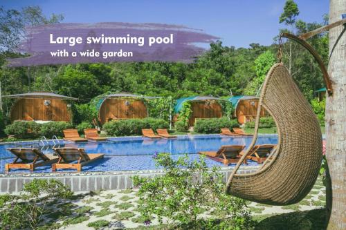 富国Phu Quoc Valley Sen Bungalow的大型游泳池设有宽阔的花园,花园内有柳条秋千