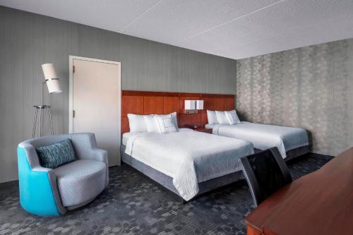 纽瓦克万怡纽瓦克自由国际机场酒店的酒店客房,配有两张床和椅子