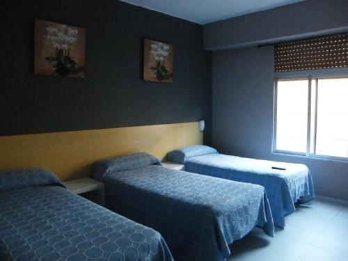 萨拉戈萨考罗纳旅馆的酒店客房设有两张床和窗户。
