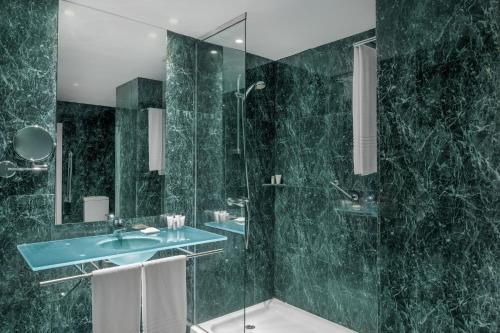 瓜达拉哈拉西班牙瓜达拉哈拉AC万豪酒店的绿色浴室设有水槽和淋浴