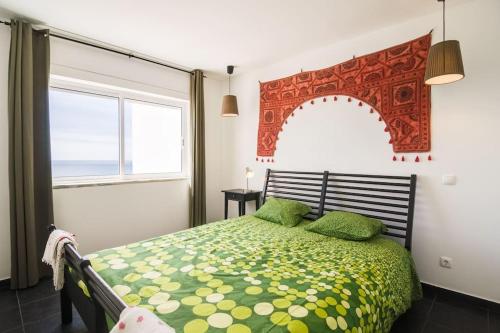 布尔高apartment with amazing sea view的一间卧室配有一张带绿色床罩的床和窗户。