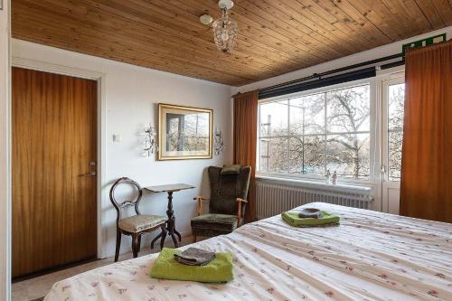 Rälla伊迪丝奥克朱莉娅住宿加早餐旅馆的卧室配有床、椅子和窗户。