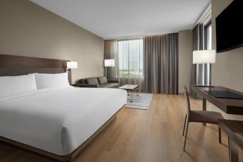黎明城AC Hotel by Marriott Fort Lauderdale Sawgrass Mills Sunrise的配有一张床和一张书桌的酒店客房