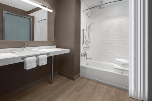黎明城AC Hotel by Marriott Fort Lauderdale Sawgrass Mills Sunrise的一间带水槽、浴缸和镜子的浴室