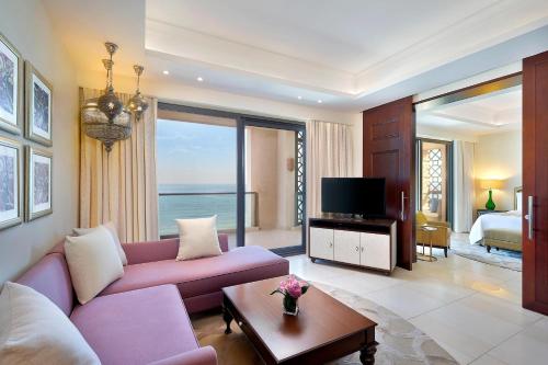 阿吉曼Ajman Saray, a Luxury Collection Resort, Ajman的客厅配有紫色沙发和电视