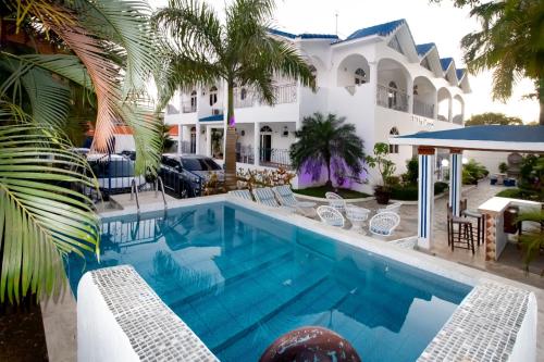 博卡奇卡Hotel Villa Capri的一座带度假村的别墅前的游泳池