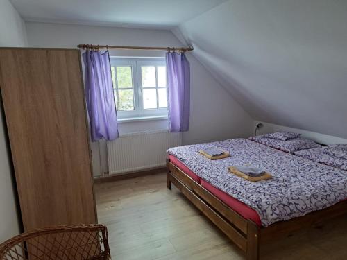 贝拉波德普拉德代姆Penzion Richard的一间卧室配有一张床和一个带紫色窗帘的窗户