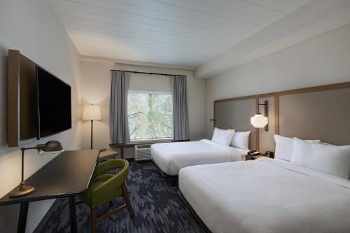 圣路易斯Fairfield Inn and Suites by Marriott St Louis Downtown的酒店客房设有两张床、一张书桌和一个窗户。