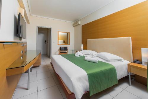 马尔马里马尔马里湾酒店的一间卧室配有一张大床和电视