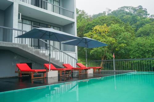 迪加纳Victoria Hideout的一组椅子和遮阳伞,位于游泳池旁