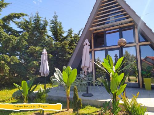 埃帕诺米DREAM House by the sea的小屋设有茅草屋顶和窗户。