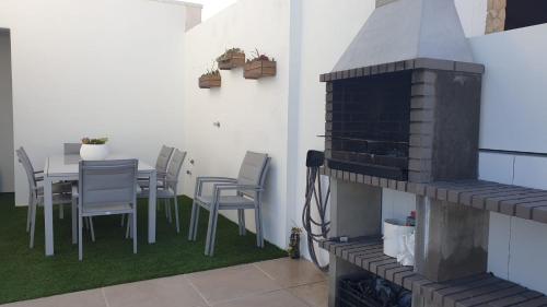 阿尔坎塔里利亚Villa Algarve的庭院配有桌椅和壁炉。
