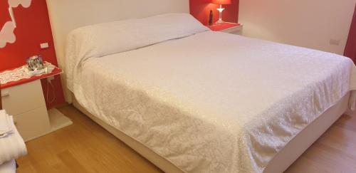 罗镇Monteceneri 9 B&b的红色墙壁的房间里一张白色的床