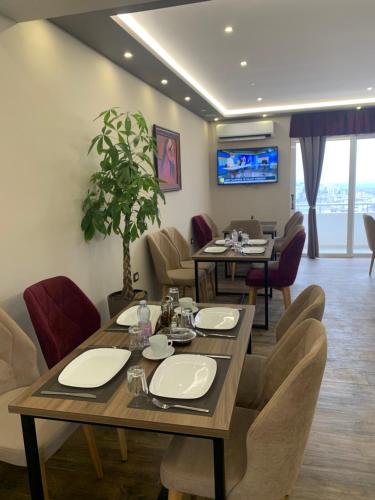 吉诺卡斯特Vladimir Estate Hotel的一间带桌椅和电视的用餐室