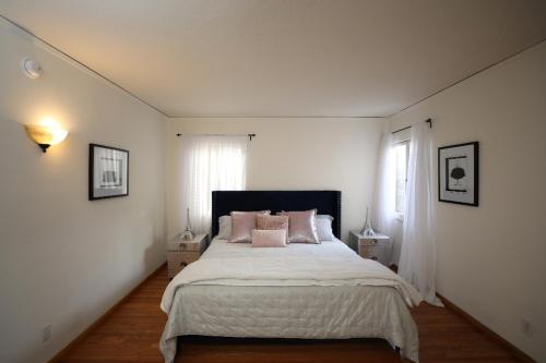 洛杉矶Renovated Spanish 3BD 2BA near Beverly Hills的白色卧室配有带粉红色枕头的大床