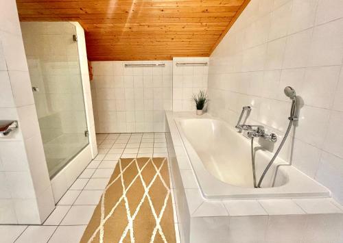 若特阿赫-埃根Ferienhaus Weißachdamm am Tegernsee的白色的浴室设有浴缸和淋浴。
