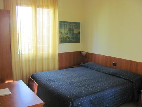 代西奥阿尔伯格加尔迪诺酒店的一间卧室配有一张床、一张桌子和一个窗户。