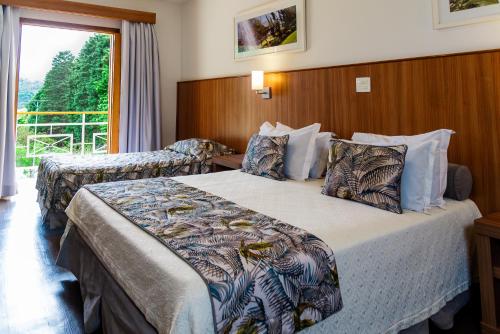 波苏斯-迪卡尔达斯Monreale Resort Parque Aquático的酒店客房设有两张床和窗户。