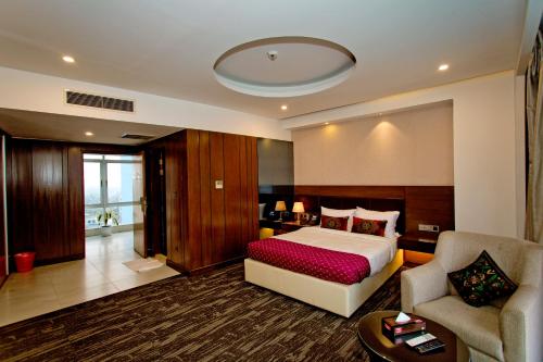杰索尔Jashore IT Park Hotel and Resort的一间卧室配有一张床、一张沙发和一把椅子