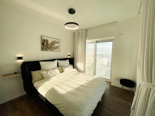 哈德拉Sea Resort的卧室配有一张大白色床和窗户