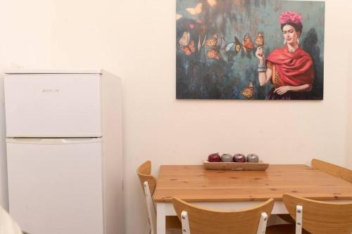 海法BrideHousehaifa的厨房配有桌子,墙上挂有绘画作品