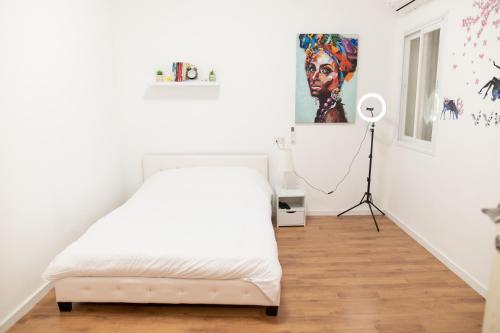 海法BrideHousehaifa的白色卧室配有床和落地灯