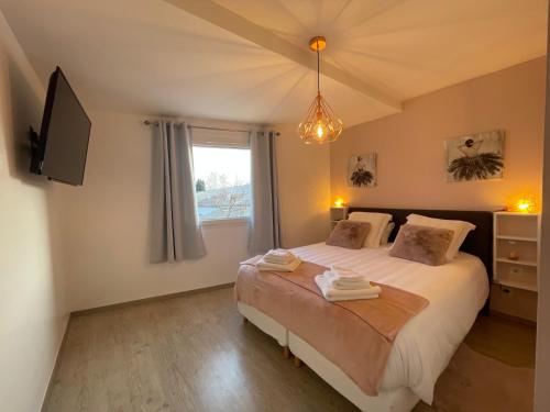 拉罗克德格兰La Maison de Jade的一间卧室设有一张床、一台电视和一个窗口。