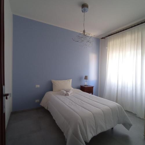 维亚雷焦Casa Minù的一间卧室配有一张白色大床和蓝色的墙壁