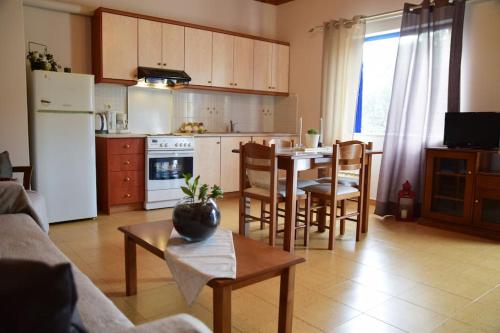 费斯卡尔德宏Affordable vintage apartment near Fiscardo & Assos的厨房以及带桌椅的起居室。