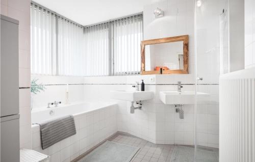滨海贝亨Villa Topduin的浴室设有2个水槽、浴缸和镜子