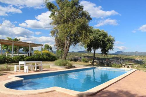 VilarrodonaRocaplana Club de Campo的庭院内的游泳池,有桌子和树木