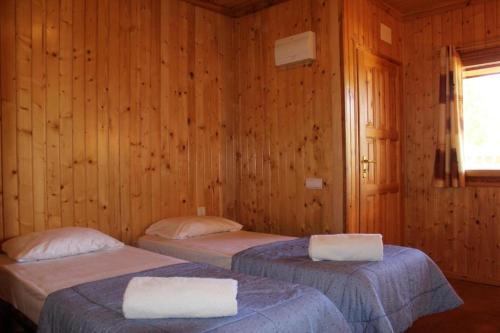 VilarrodonaRocaplana Club de Campo的木墙客房的两张床