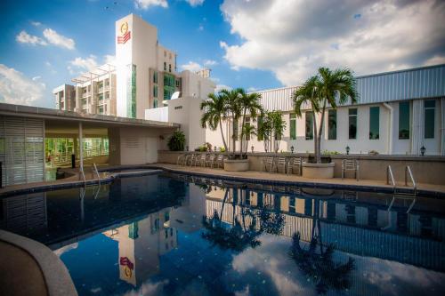 罗勇Golden City Rayong Hotel - SHA Extra Plus Certified的棕榈树建筑前的游泳池