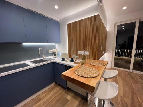 阿马尔菲SeaJewelsDeluxurySuite的厨房配有蓝色橱柜和木桌