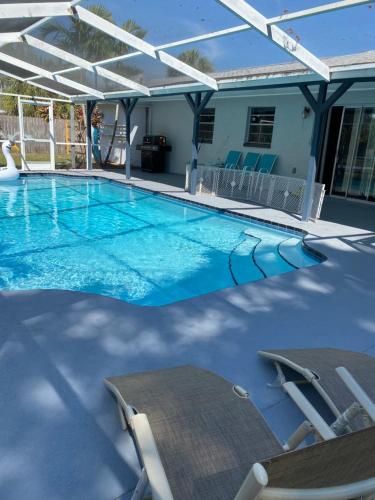 West MelbournePool house near beach的一个带椅子和遮阳伞的大型游泳池