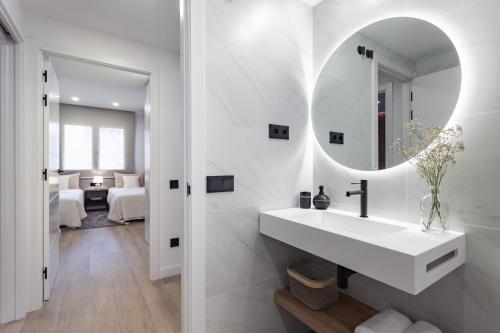 巴塞罗那ApartsNouBcn Equador Les Corts的白色的浴室设有水槽和镜子