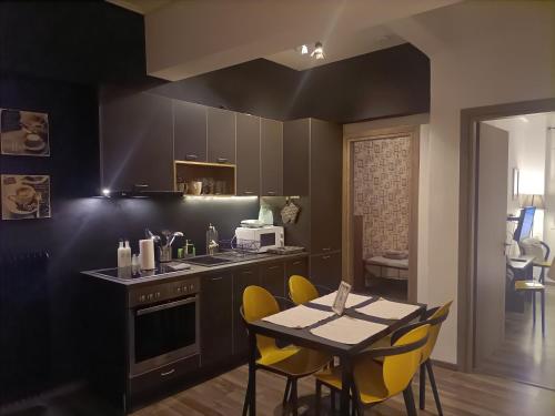雅典Kallimarmaro Cozy的厨房配有黄色的椅子和一张桌子及柜台