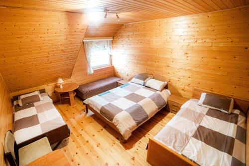 DzērbeneViesu nams SAKNĪTES的小木屋内一间卧室,配有两张床