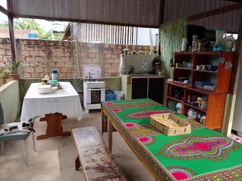 阿尔特杜尚Caju Hostel的一间设有桌子的房间和一间带桌子的四柱床的厨房
