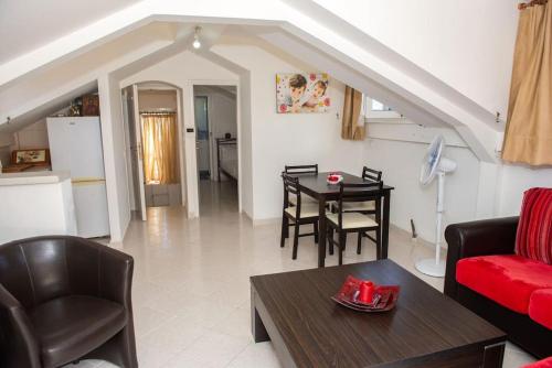 扎金索斯镇Attic flat ''Tsoukalas Group''的客厅配有红色的沙发和桌子