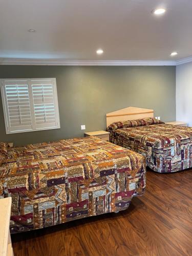 加迪纳市El Rey Inn的铺有木地板的客房内的两张床