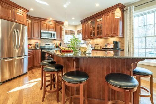 托比汉纳Luxury 4 bedroom house in Pocono Mountains in Golf course Near Lake的一个带木柜的厨房和一个带酒吧凳的大岛