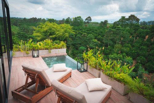 金巴亚Amanatu Ecolodge & Spa的一个带椅子的庭院和一个位于甲板上的游泳池