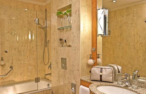 波茨坦伽戈托尔酒店的带淋浴、盥洗盆和浴缸的浴室