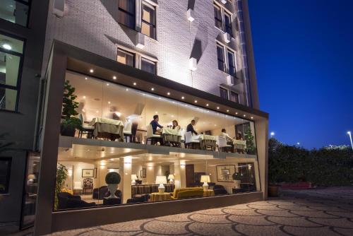 卡利亚里撒丁岛套房和餐厅酒店的一群人坐在大楼的阳台上