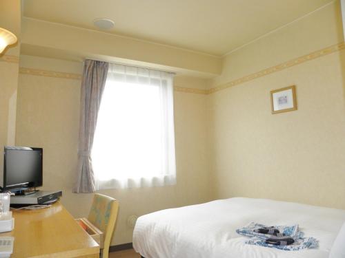 米泽市Yonezawa - Hotel / Vacation STAY 16072的一间卧室配有一张床、一张书桌和一个窗户。