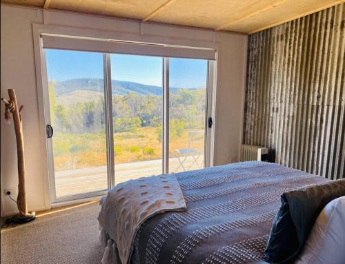CobungraShiki Snow Cabin的一间卧室设有一张床和一个大窗户