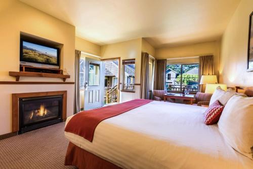 卡农海滩坎农比奇酒店的一间卧室设有一张大床和一个壁炉