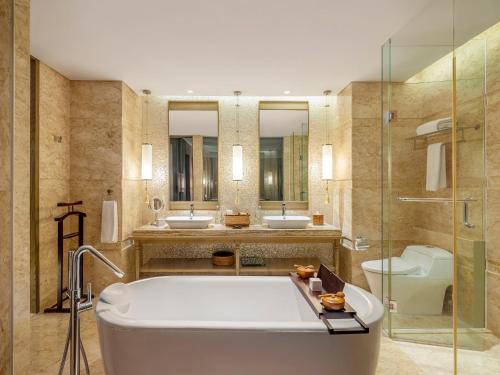 金巴兰莫瓦匹克金巴兰巴厘岛度假Spa酒店的带浴缸、两个盥洗盆和卫生间的浴室