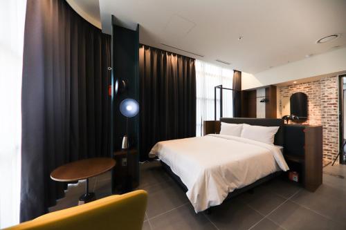 首尔LE SEOUL HOTEL的卧室配有1张床、1张桌子和1把椅子